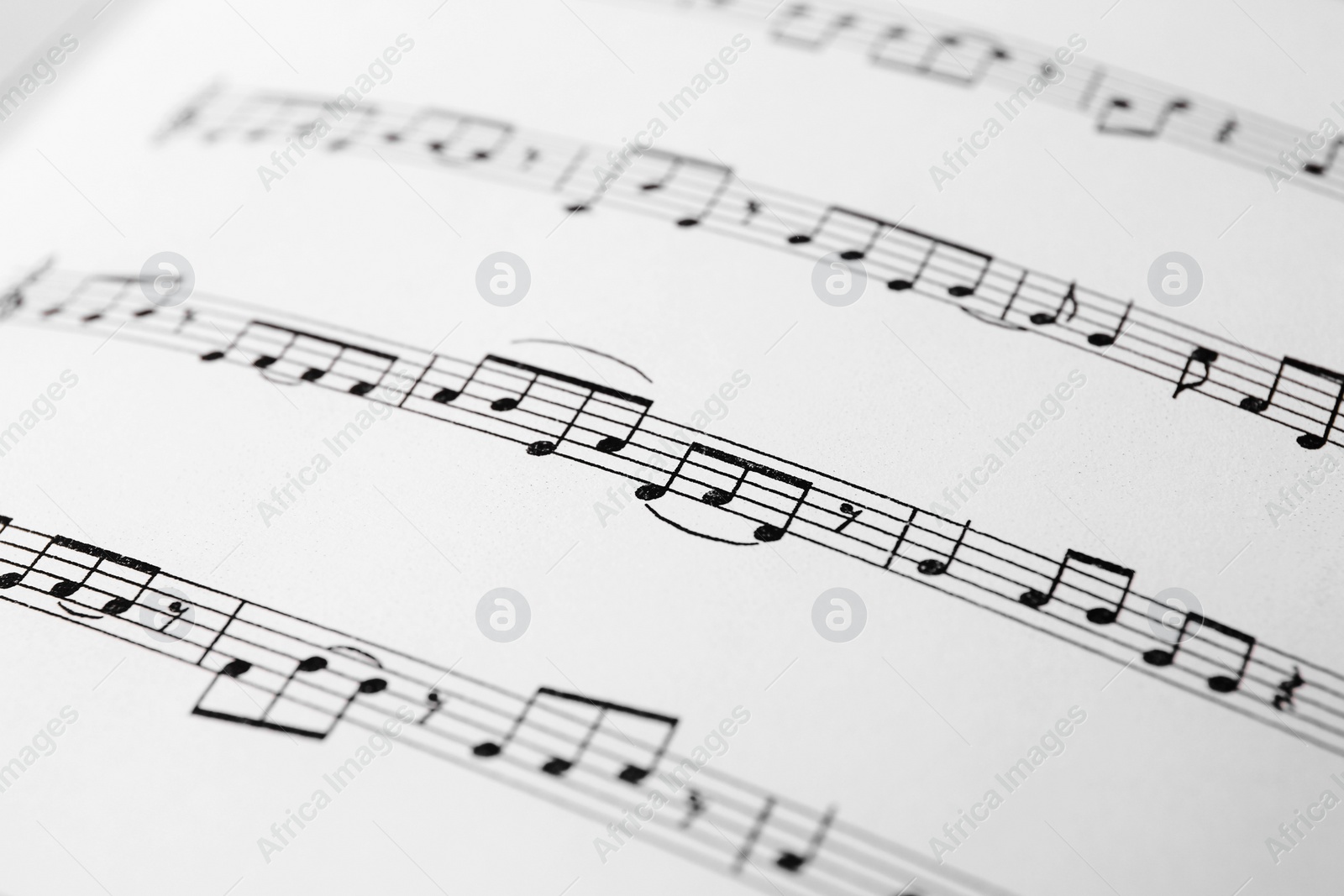 Photo of Sheet of paper with music notes as background, closeup