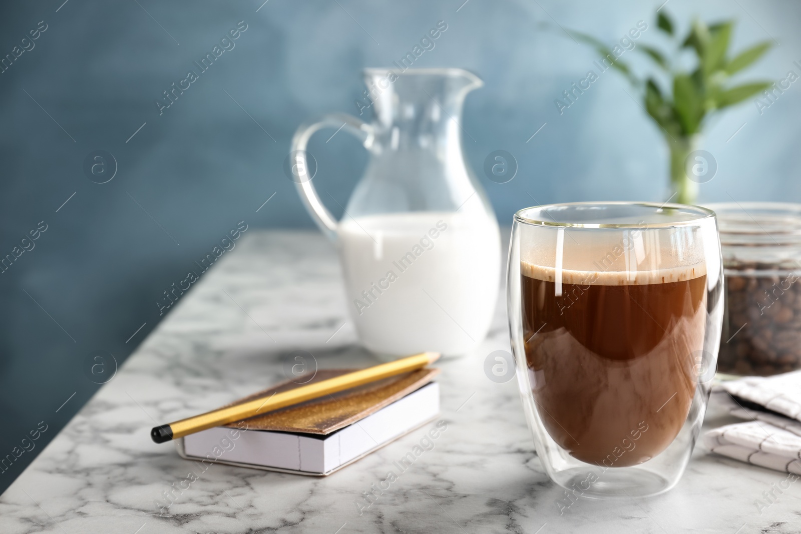 Photo of Glass of aromatic hot coffee on marble table