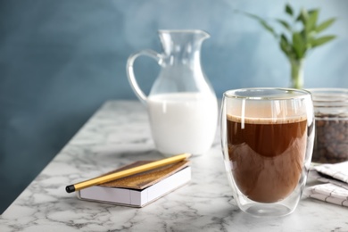 Photo of Glass of aromatic hot coffee on marble table