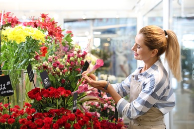 Photo of Beautiful female florist working in flower shop