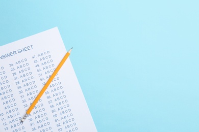 Photo of Answer sheet and pencil on color background, top view with space for text