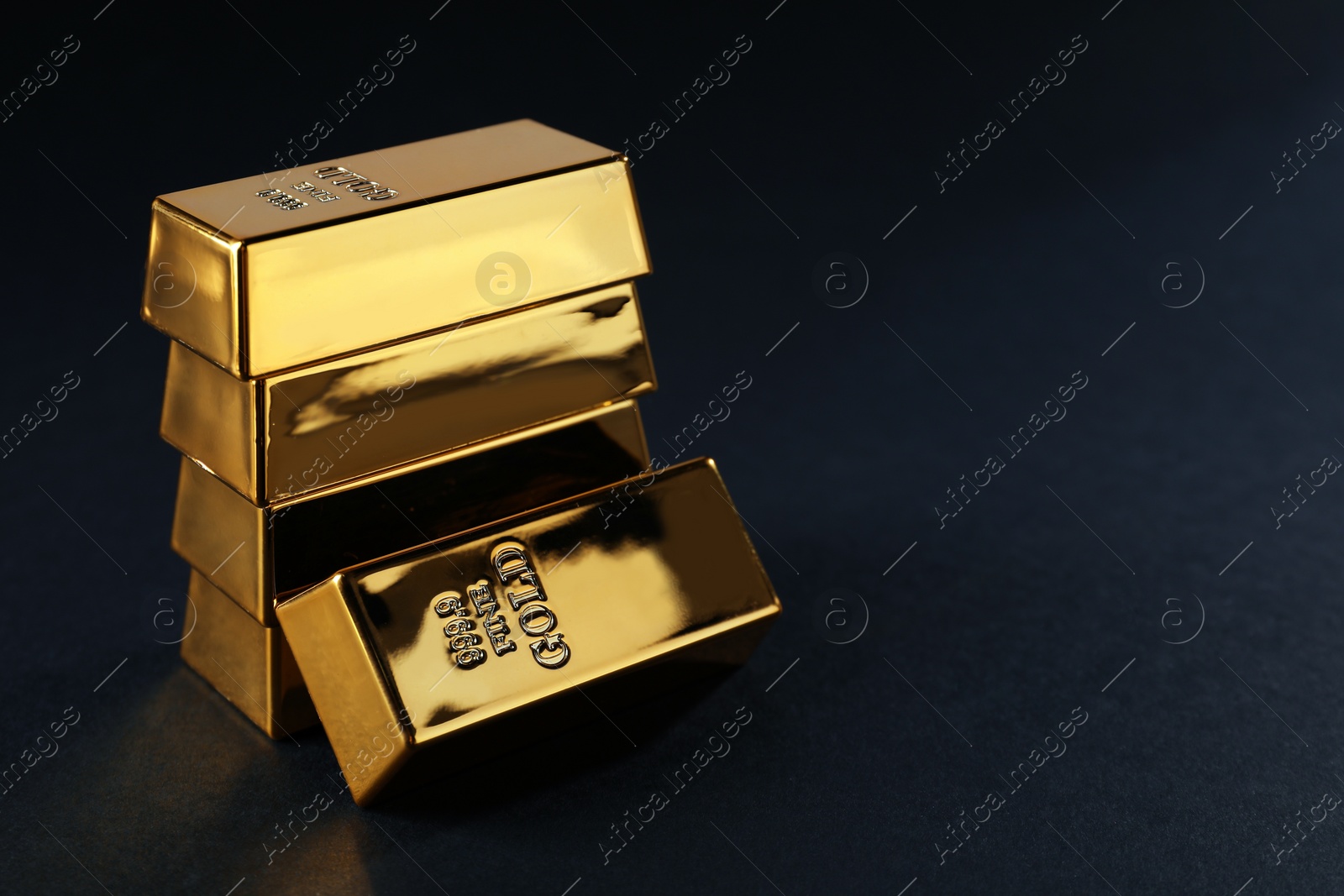 Photo of Many shiny gold bars on black background. Space for text