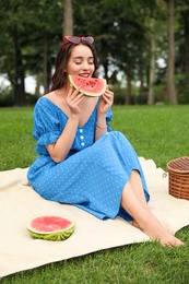 Beautiful young woman with watermelon in park on sunny day