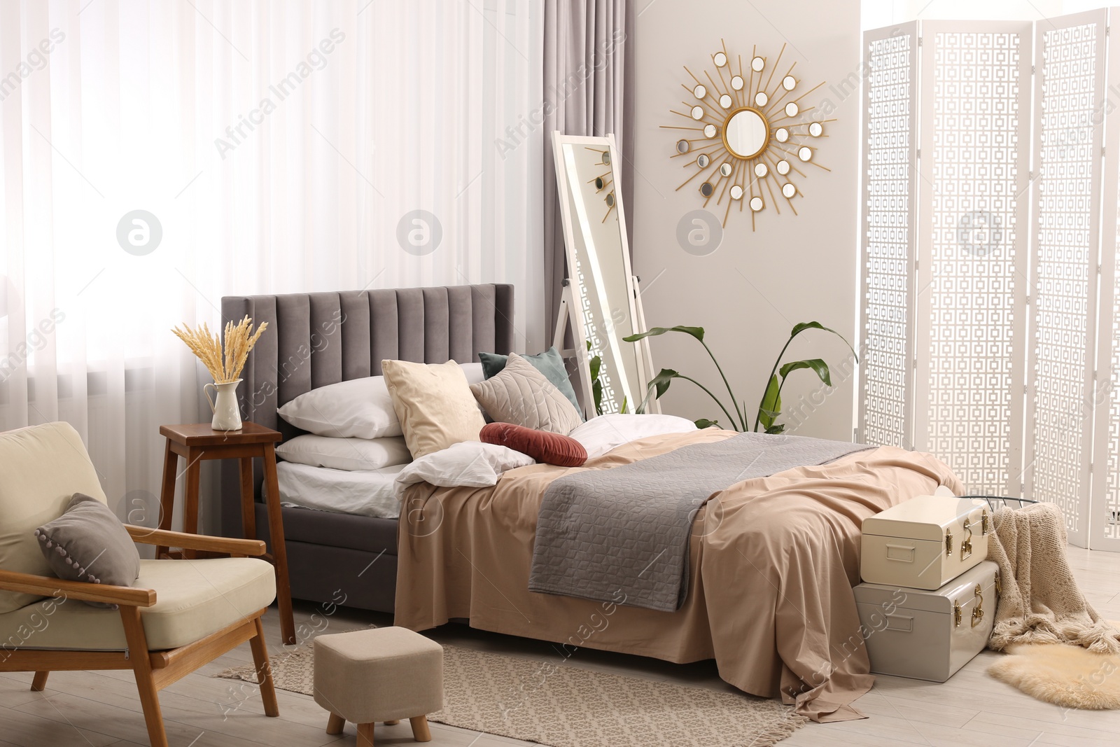 Photo of Large comfortable bed with soft pillows and blankets in room. Home textile