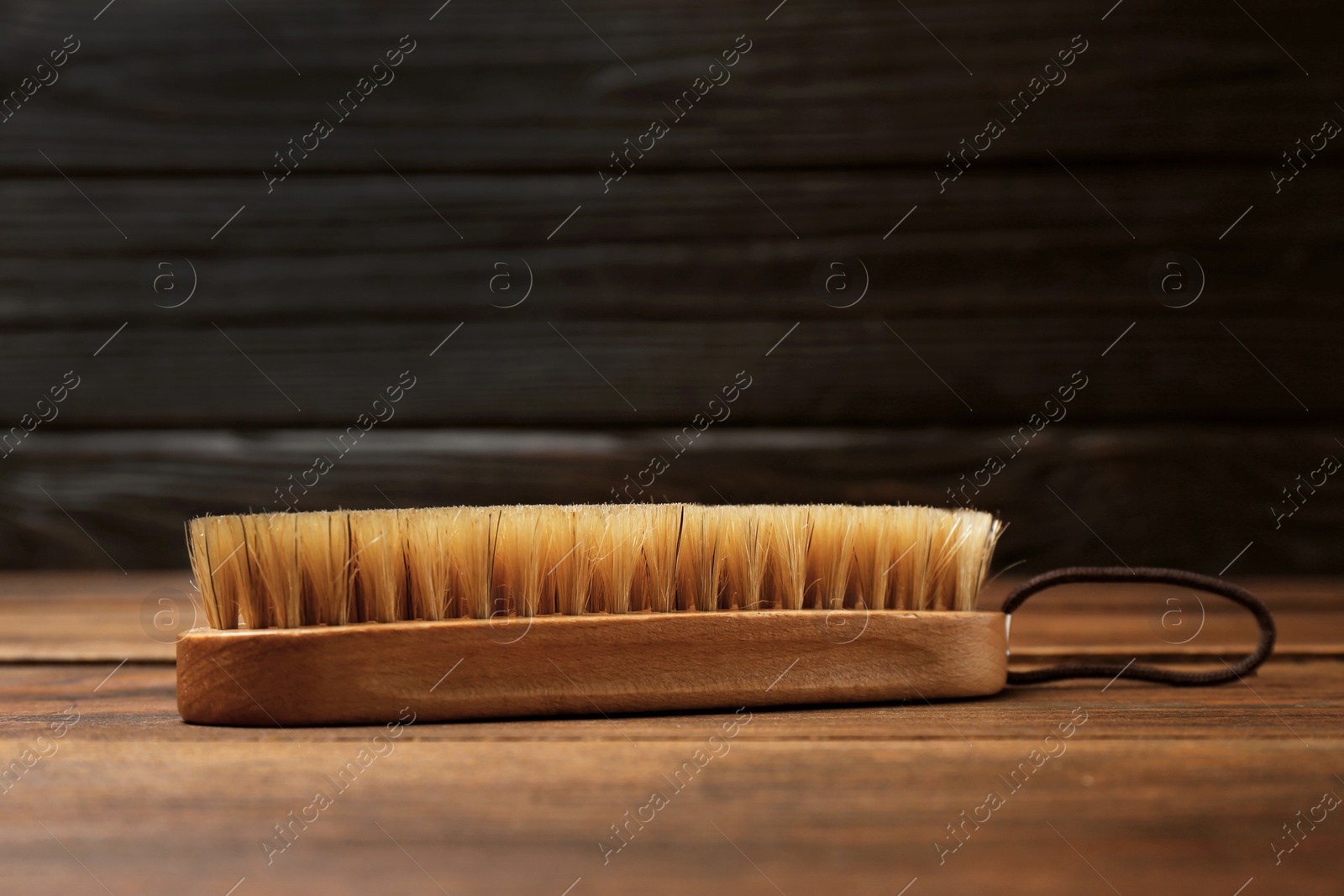 Photo of Shoe brush on wooden table. Footwear care item