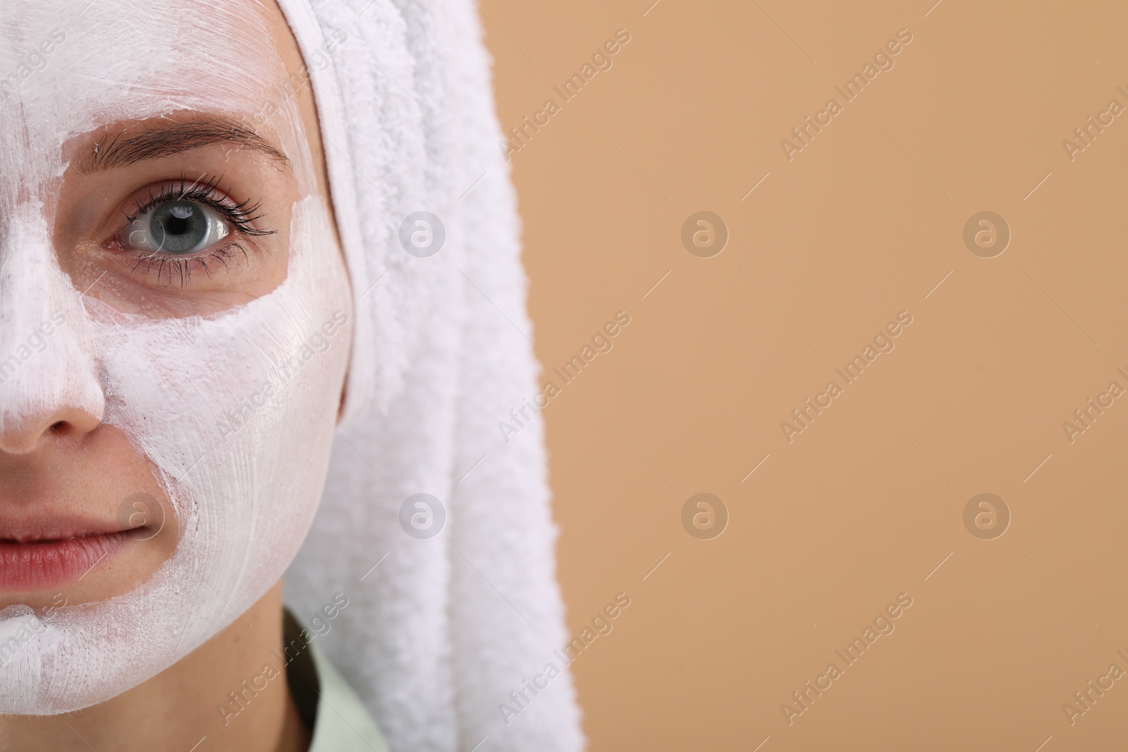 Photo of Woman with face mask on beige background, closeup and space for text. Spa treatments