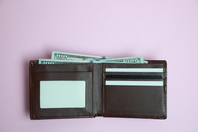 Photo of Stylish brown leather wallet with dollar banknotes on light background, top view. Space for text