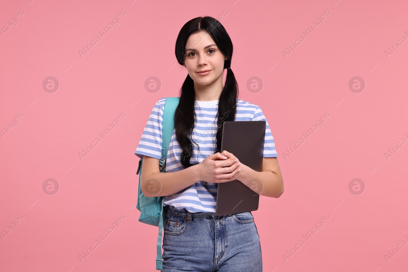 Photo of Cute student with laptop on pink background