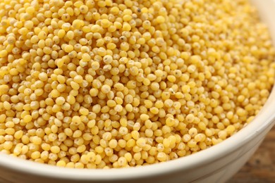 Photo of Millet groats in bowl on table, closeup