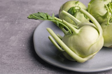 Photo of Whole ripe kohlrabi plant on grey table, closeup