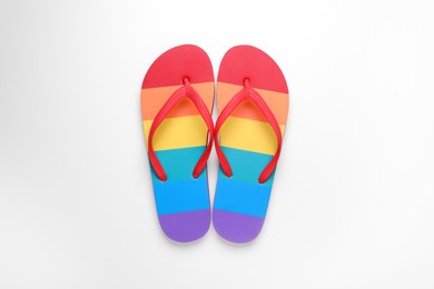 Photo of Rainbow flip flops on white background, top view. LGBT pride