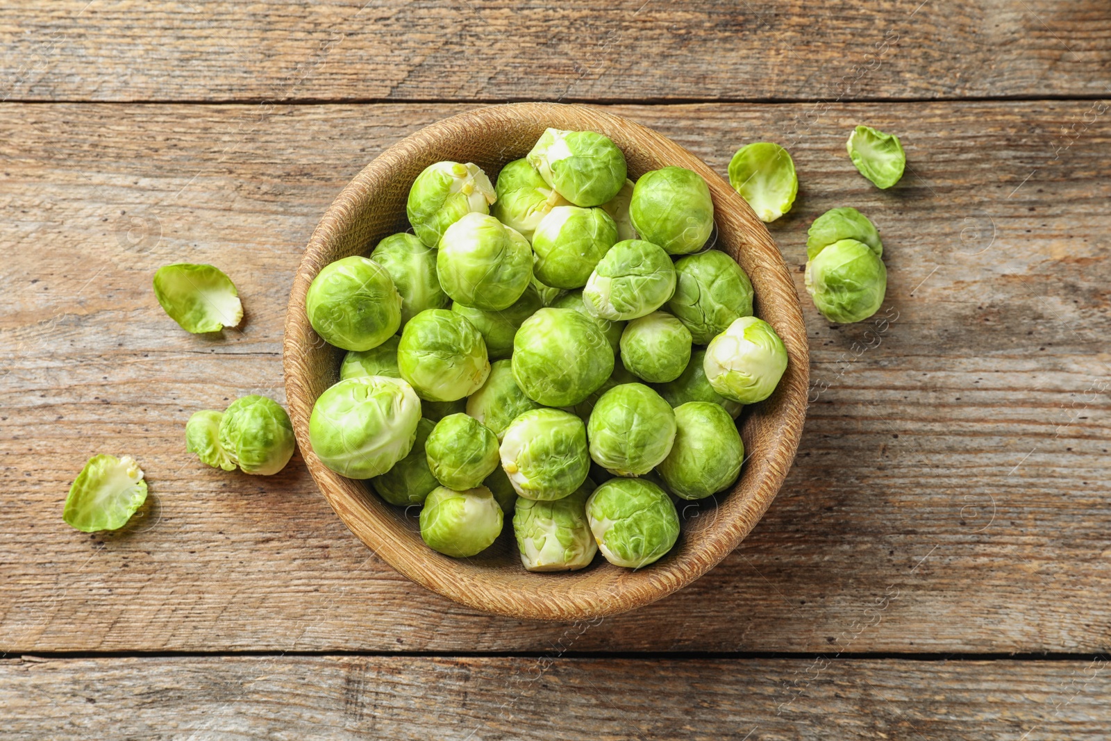 Photo of Bowl of fresh Brussels sprouts on wooden background, top view