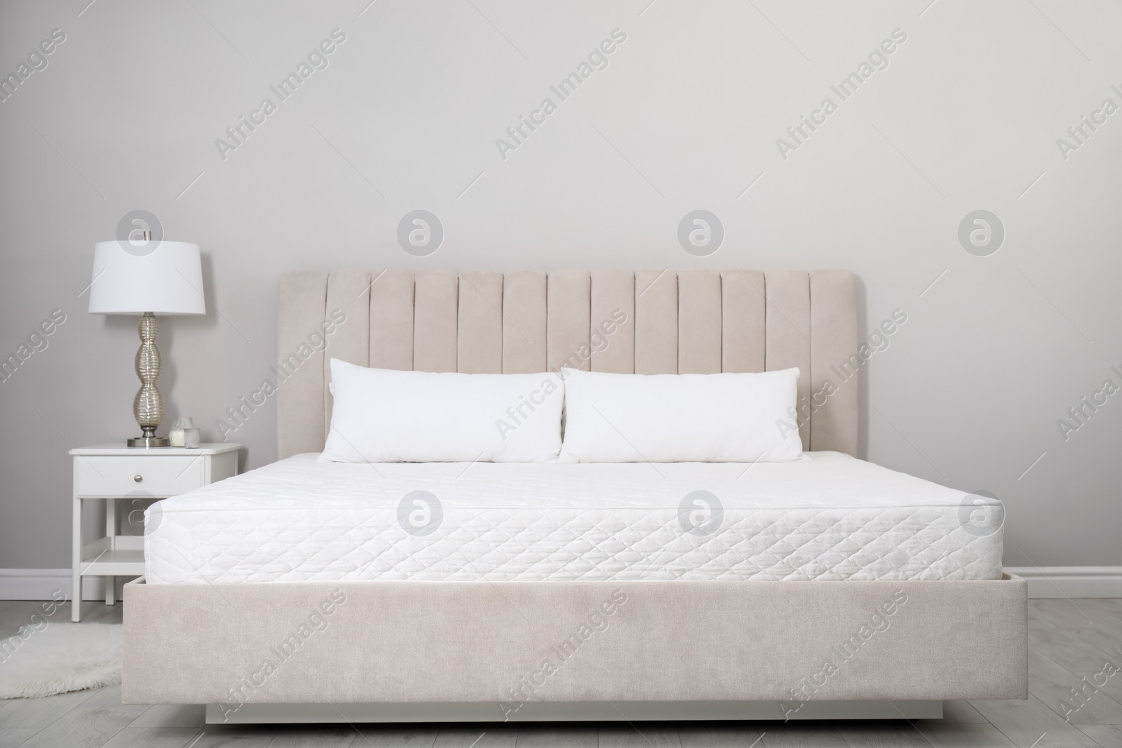 Photo of Comfortable bed with soft white mattress and pillows indoors
