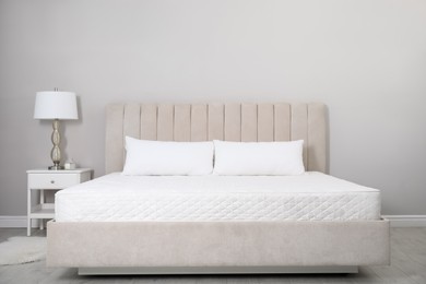 Photo of Comfortable bed with soft white mattress and pillows indoors