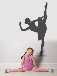 Image of Cute little girl dreaming to be ballet dancer. Silhouette of woman behind kid's back