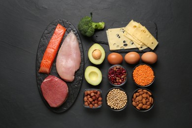 Photo of Different fresh products on black table, flat lay. Sources of essential amino acids