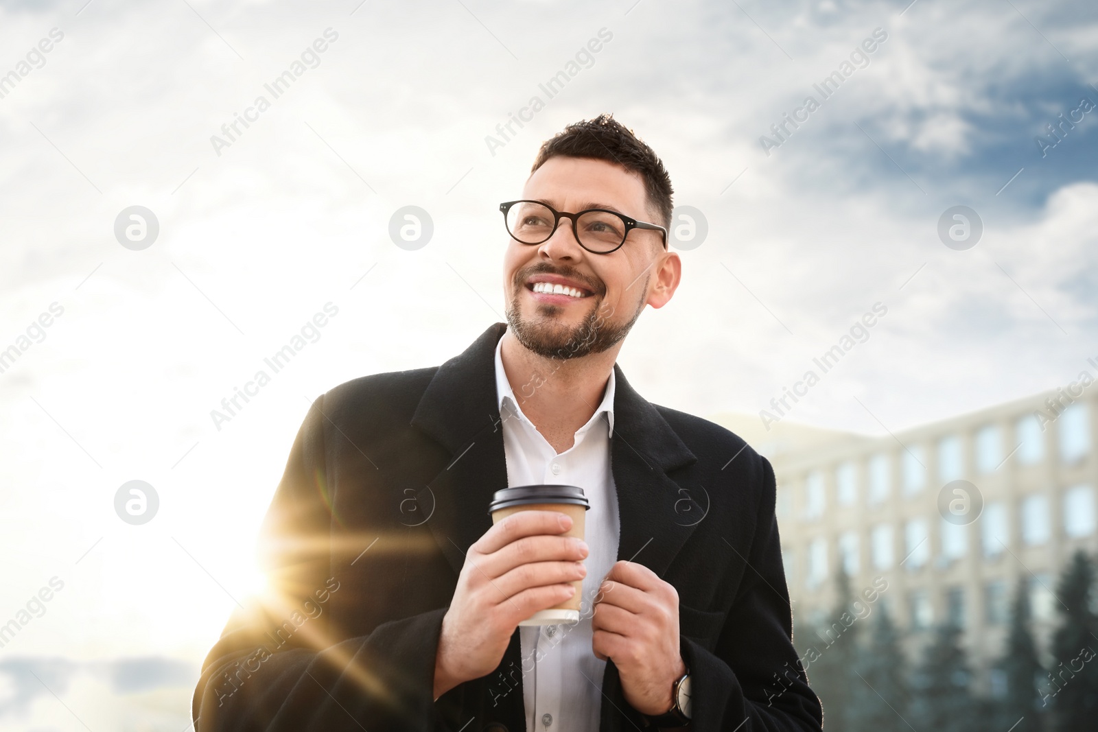 Photo of Man with cup of coffee on city street in morning