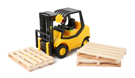 Photo of Toy forklift and wooden pallets on white background