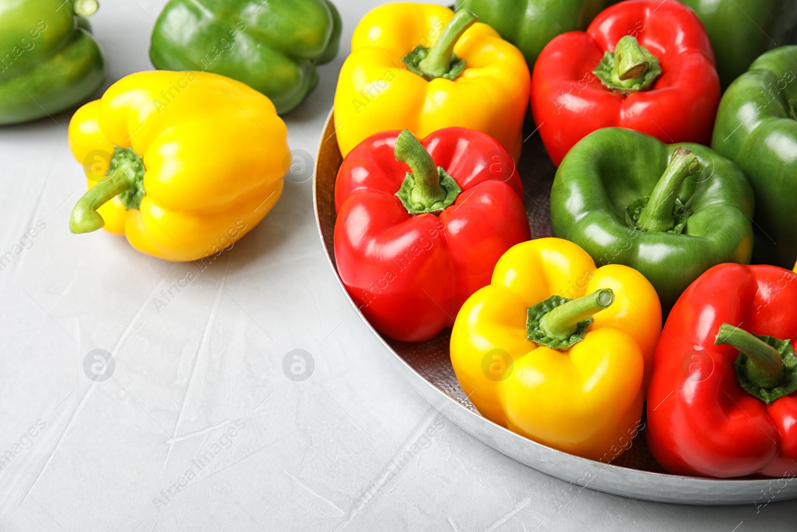 Photo of Dish with ripe paprika peppers on light background