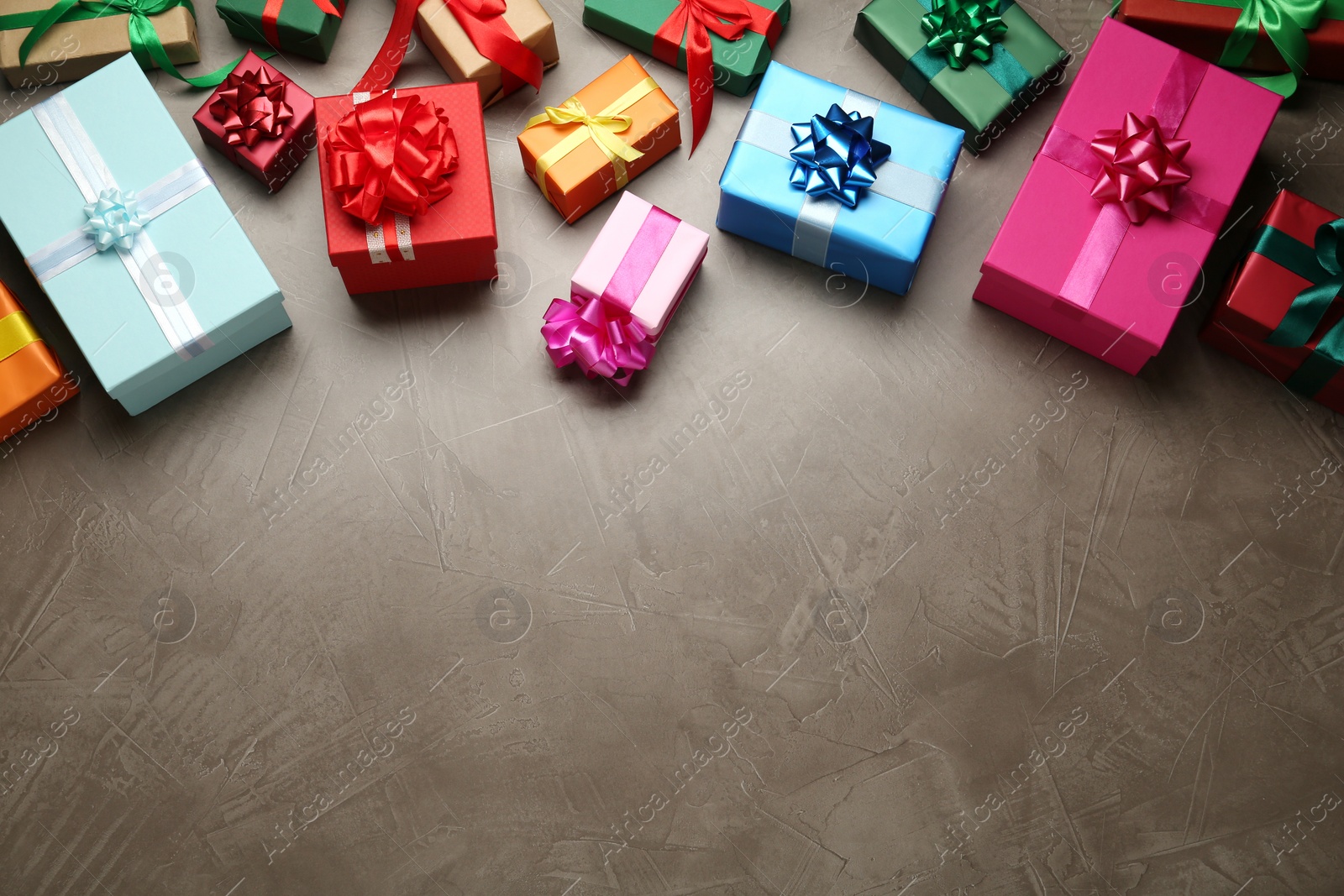 Photo of Many colorful gift boxes on grey table, above view. Space for text