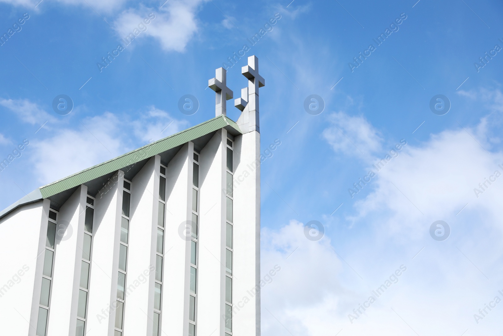 Photo of Exterior of modern church against blue sky with clouds