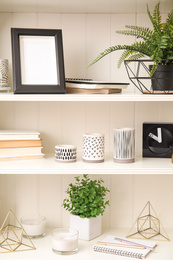 Photo of White shelving unit with plants and different decorative stuff