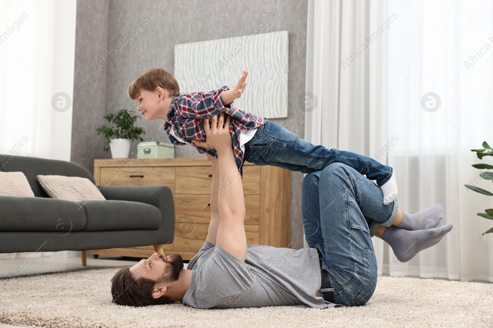 Photo of Happy dad and son having fun together at home