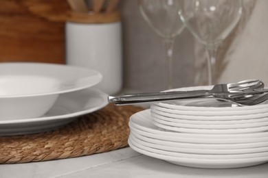 Photo of Clean dishes and cutlery on table in kitchen, closeup