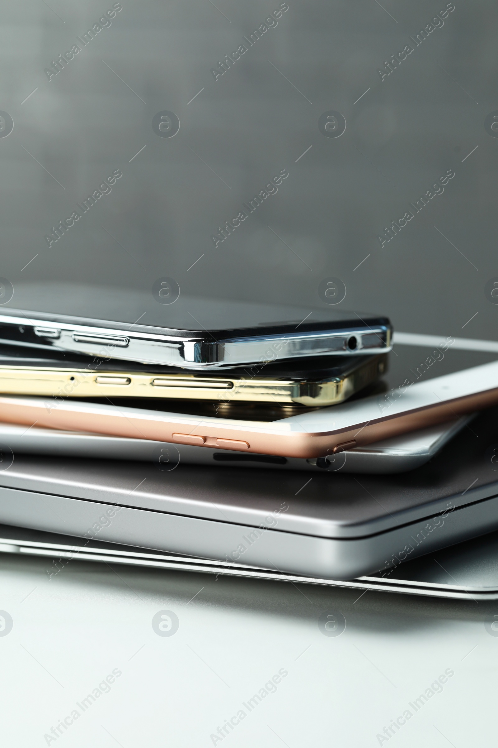 Photo of Stack of electronic devices on white table, closeup