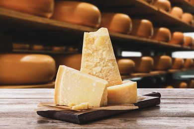 Delicious parmesan cheese on wooden table in warehouse 