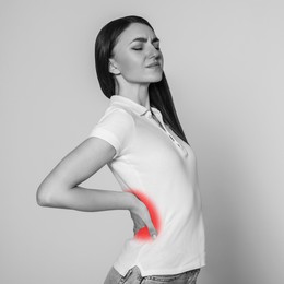 Image of Woman suffering from rheumatism on light background. Black and white effect with red accent in painful area