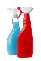 Photo of Spray bottles with detergents on white background. Cleaning supplies
