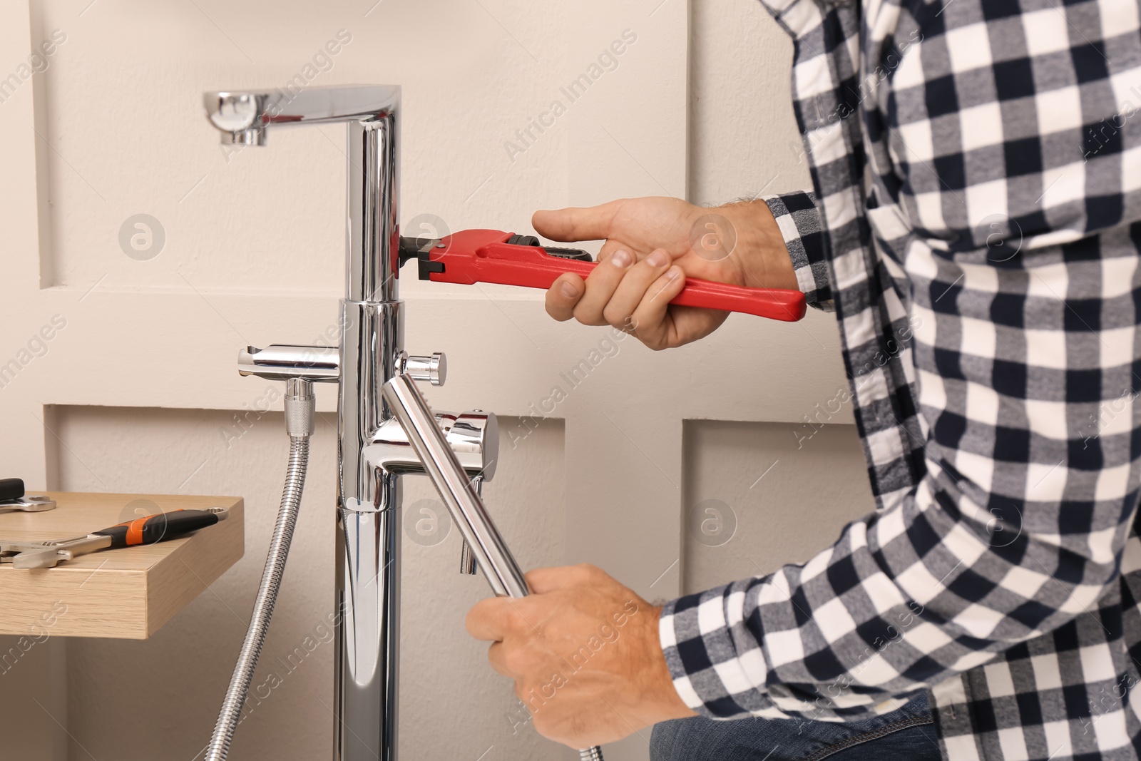 Photo of Man installing water tap in bathroom, closeup
