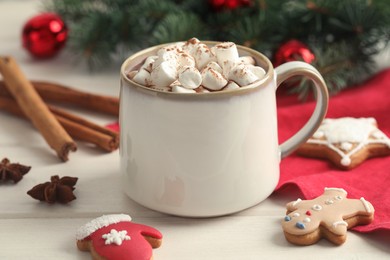 Photo of Delicious hot chocolate with marshmallows and Christmas cookies on white wooden table, closeup