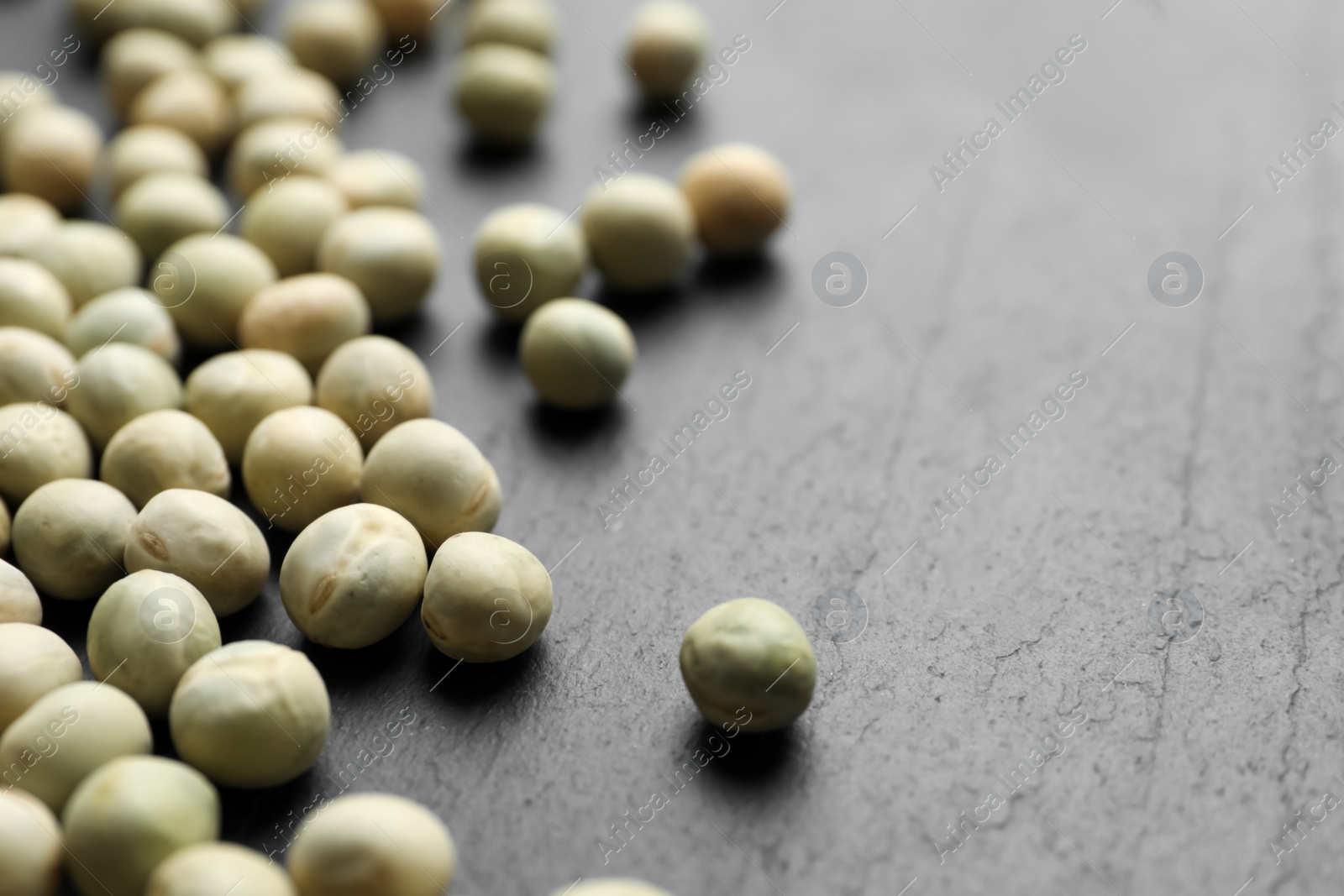 Photo of Raw dry peas on grey background, closeup. Vegetable seeds