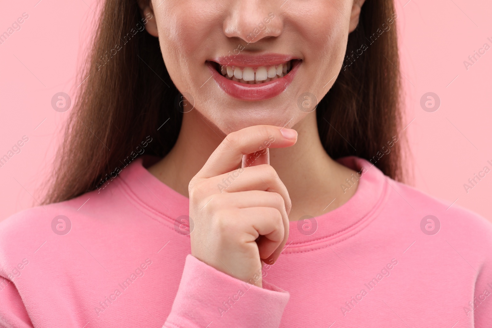 Photo of Woman with clean teeth smiling on pink background, closeup