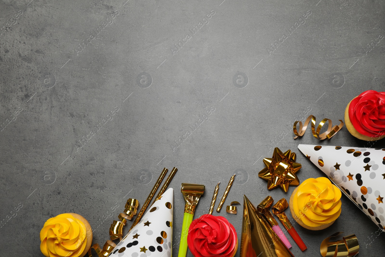 Photo of Flat lay composition with colorful birthday cupcakes on grey table. Space for text