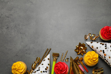 Flat lay composition with colorful birthday cupcakes on grey table. Space for text