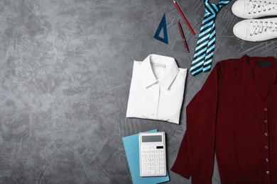 Photo of Flat lay composition with school uniform on grey background. Space for text