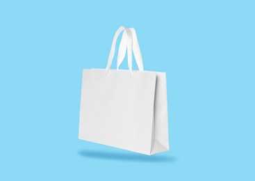 Image of White paper bag on turquoise background. Mockup for design