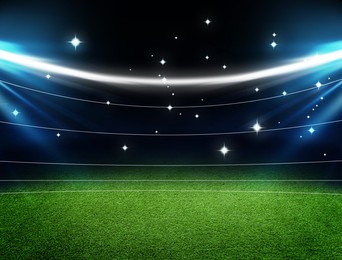 Image of Empty green sports field under stadium lights