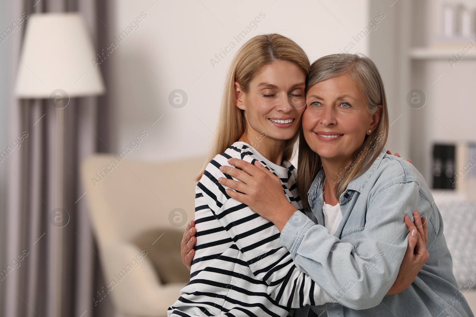 Photo of Happy mature mother and her daughter at home, space for text