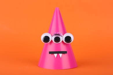 Photo of Spooky paper Halloween monster on orange background