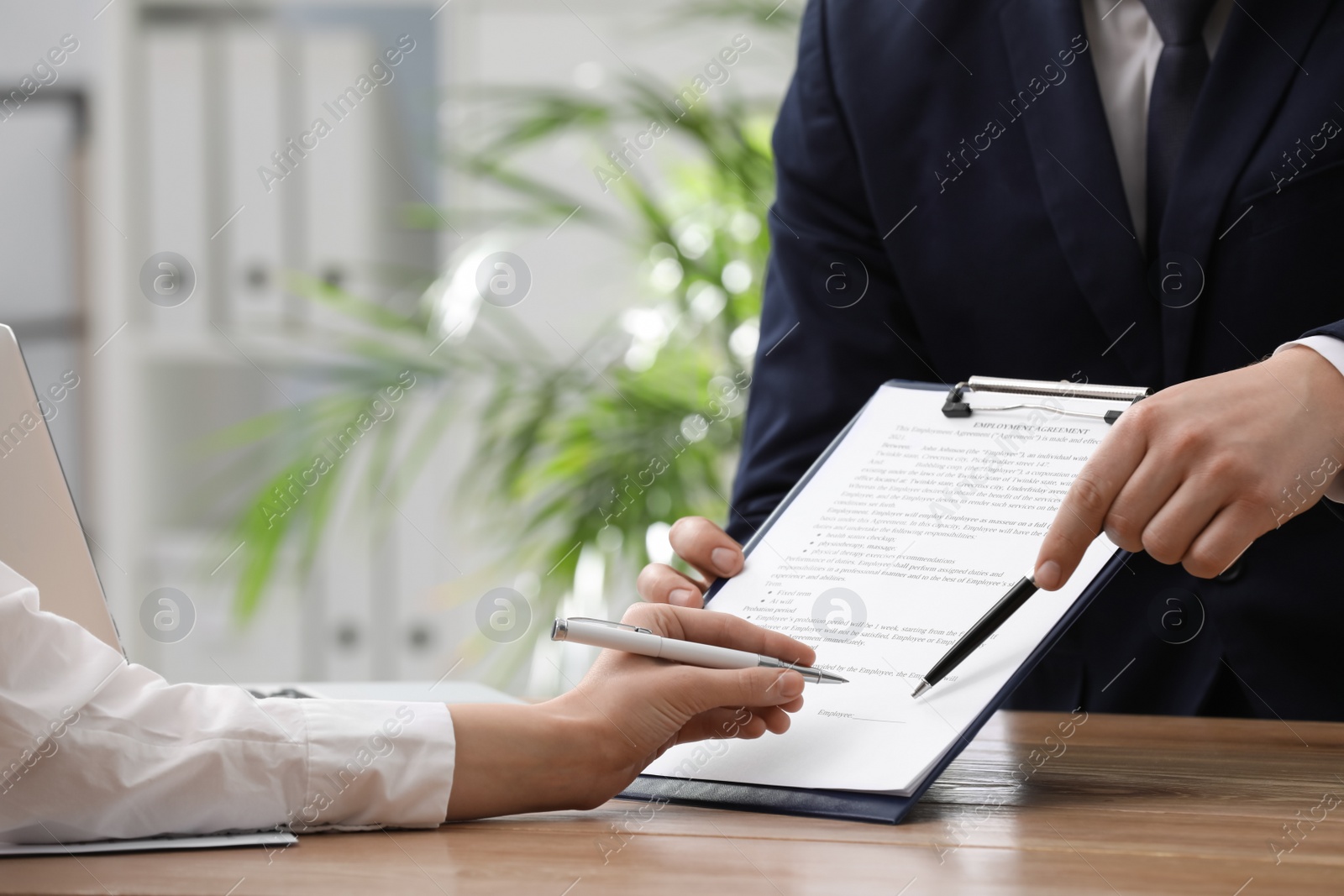 Photo of Woman signing employment agreement with HR manager in office, closeup. Work contract