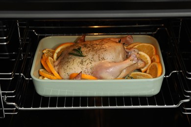 Photo of Chicken with orange slices baking in oven