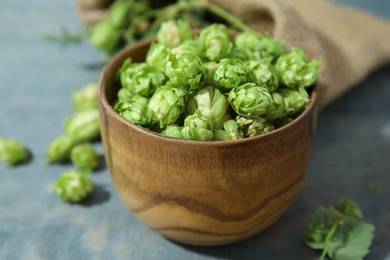 Photo of Bowl with fresh green hops on wooden table. Beer production