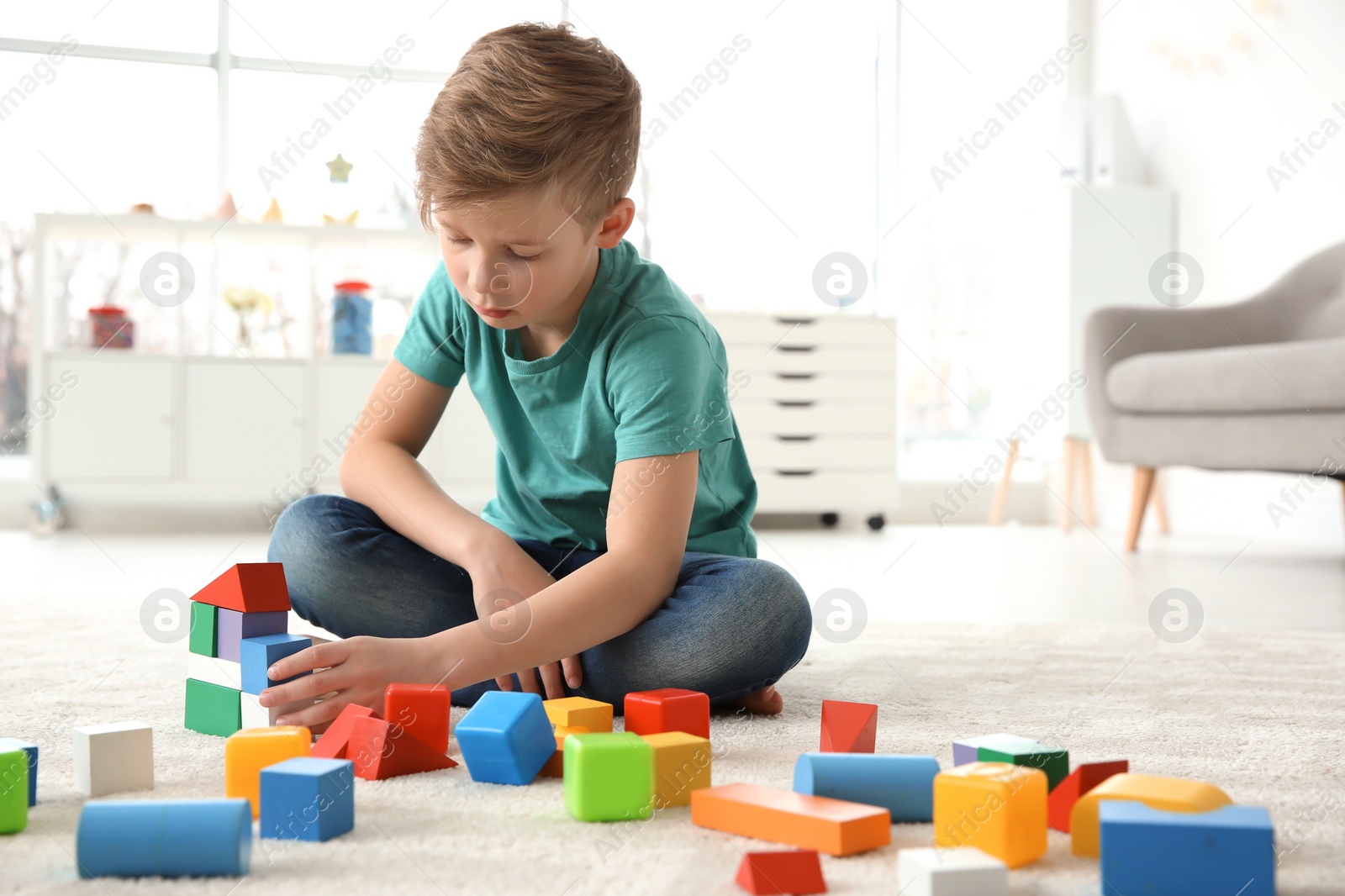 Photo of Little autistic boy playing with cubes at home