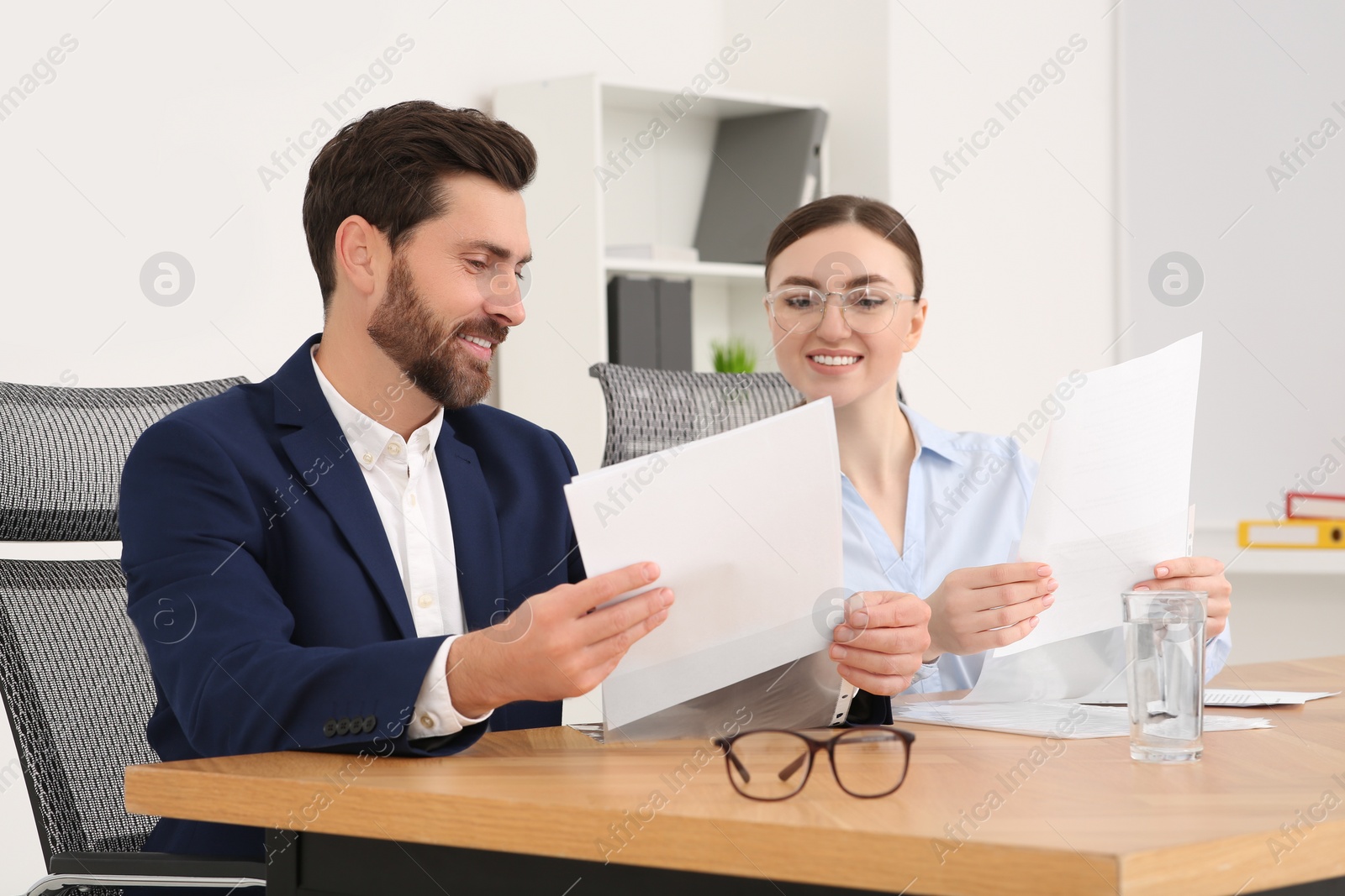 Photo of Businesspeople working together with documents in office