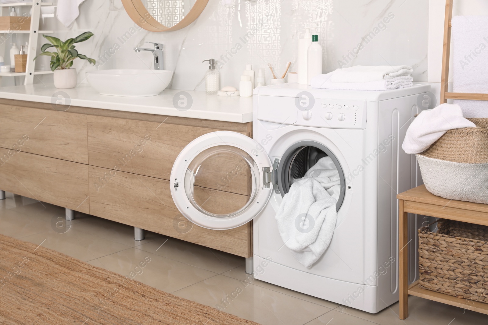 Photo of Stylish bathroom interior with modern washing machine