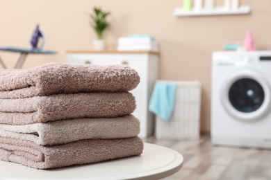 Photo of Stack of towels on table against blurred background, space for text